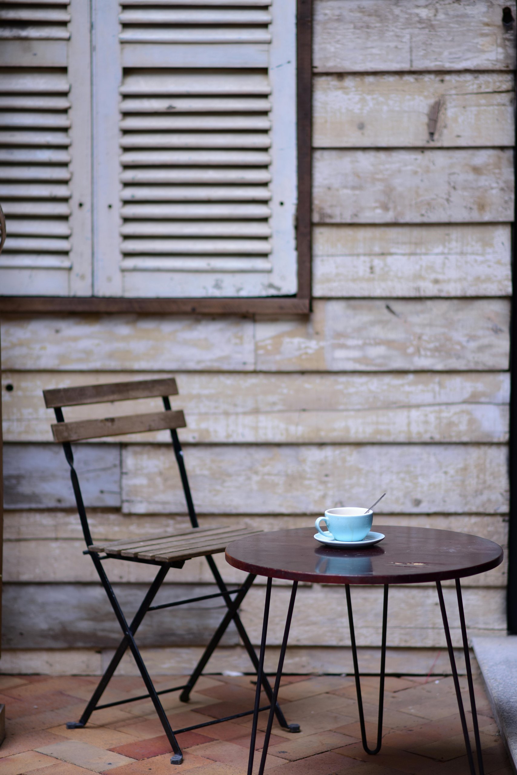 n-empty-wooden-chair-or-simple-stool-in-soft-natural-light-with-an-unfinished-cup-of-coffee-nearby