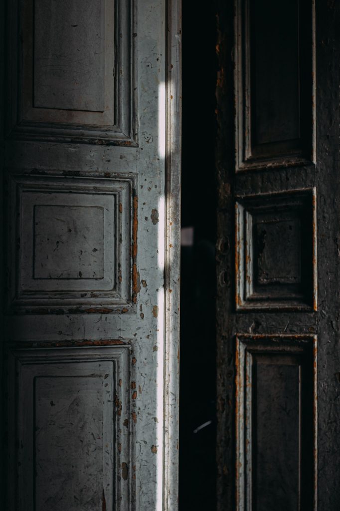 A-heavy-old-wooden-door-standing-slightly-ajar