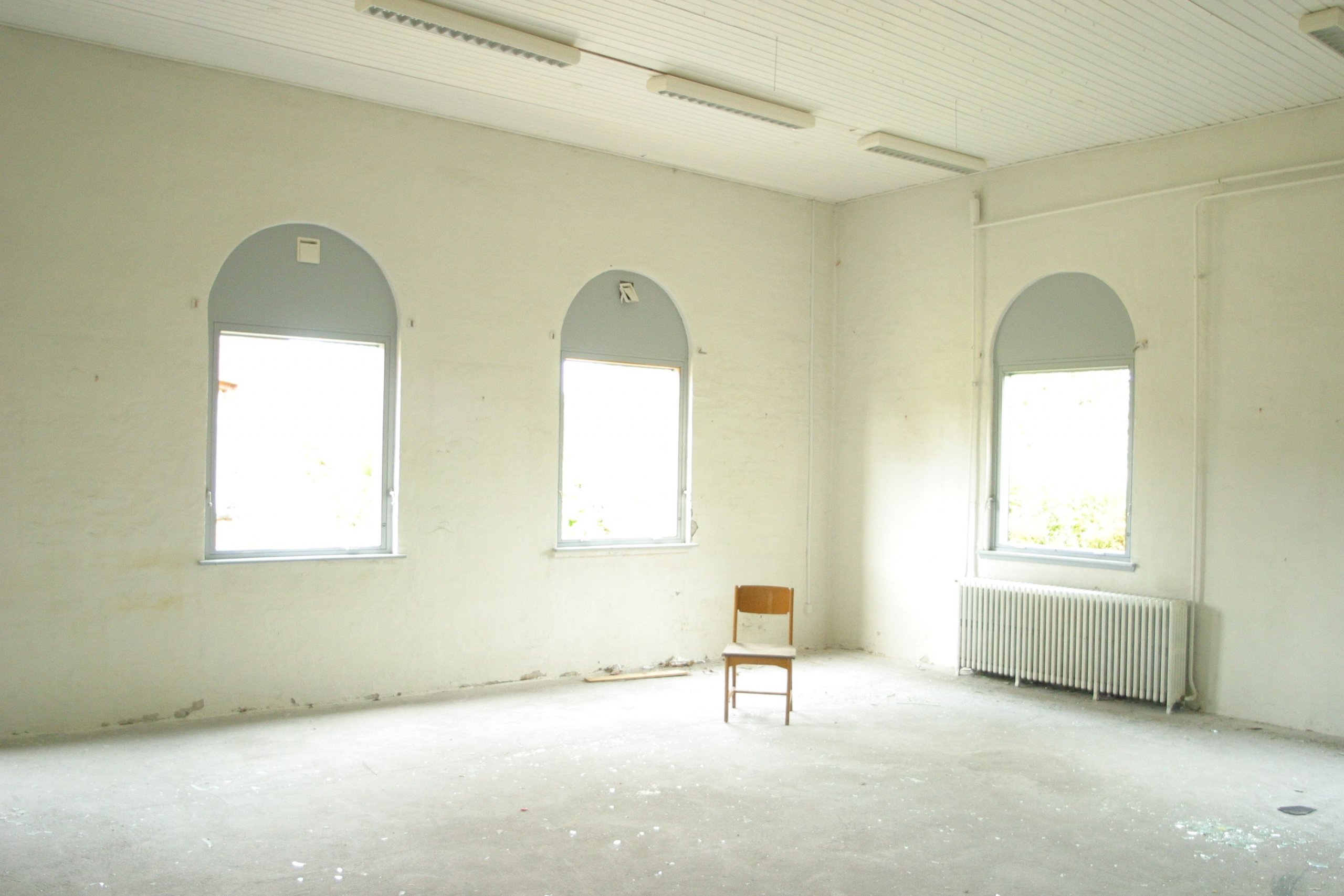 A-single-empty-chair-by-a-window-in-soft-light