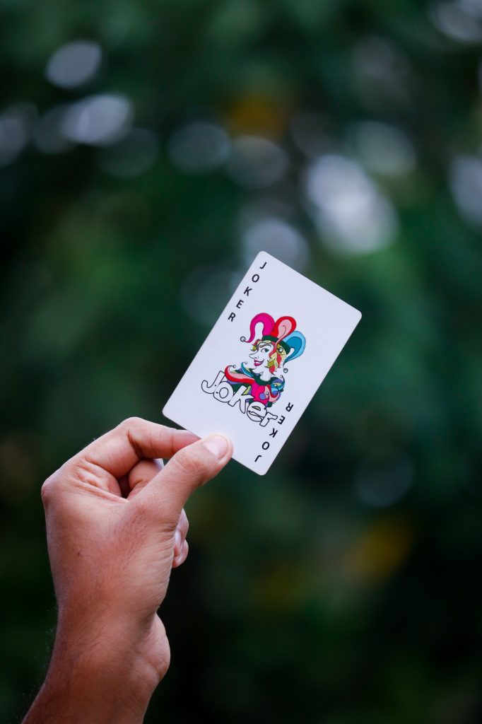 A-single-joker-playing-card-lying-face-up-on-dark-green-felt