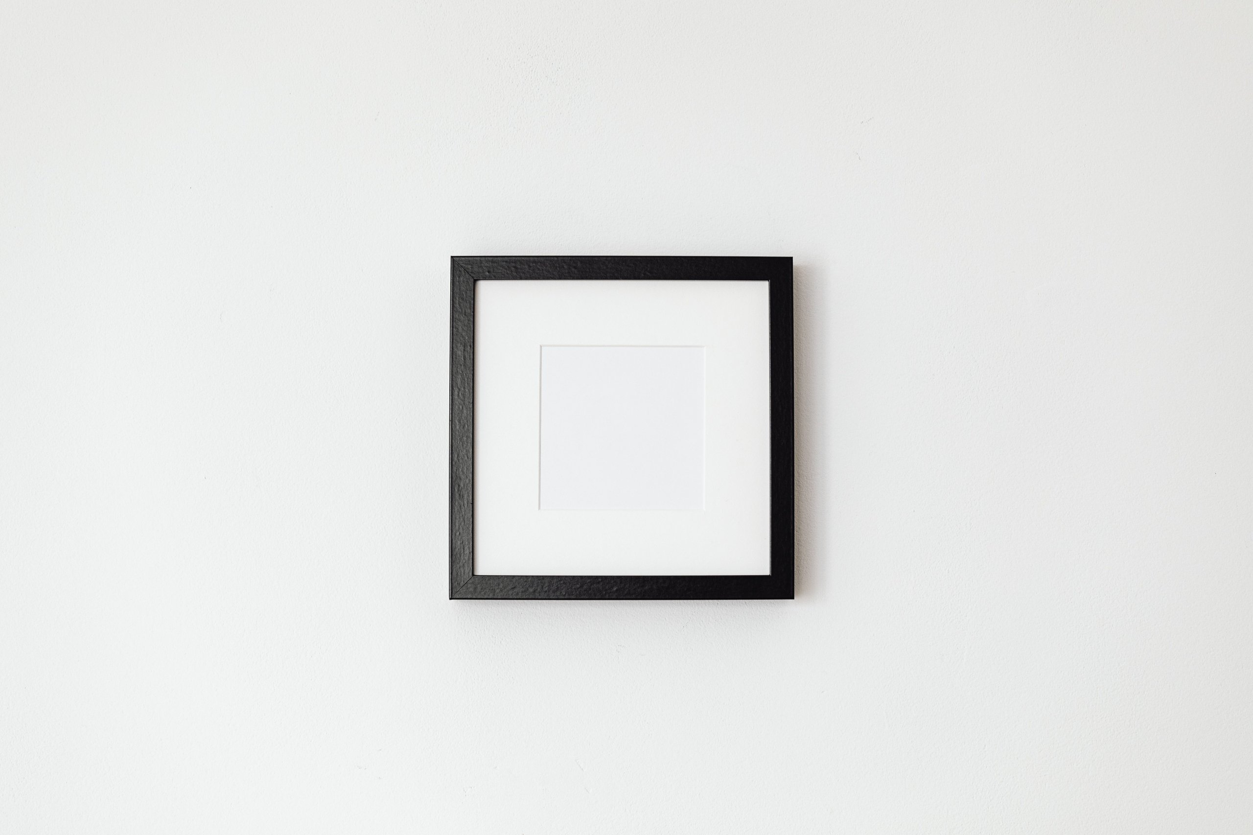 an-old-empty-picture-frame-hanging-on-a-bare-wall