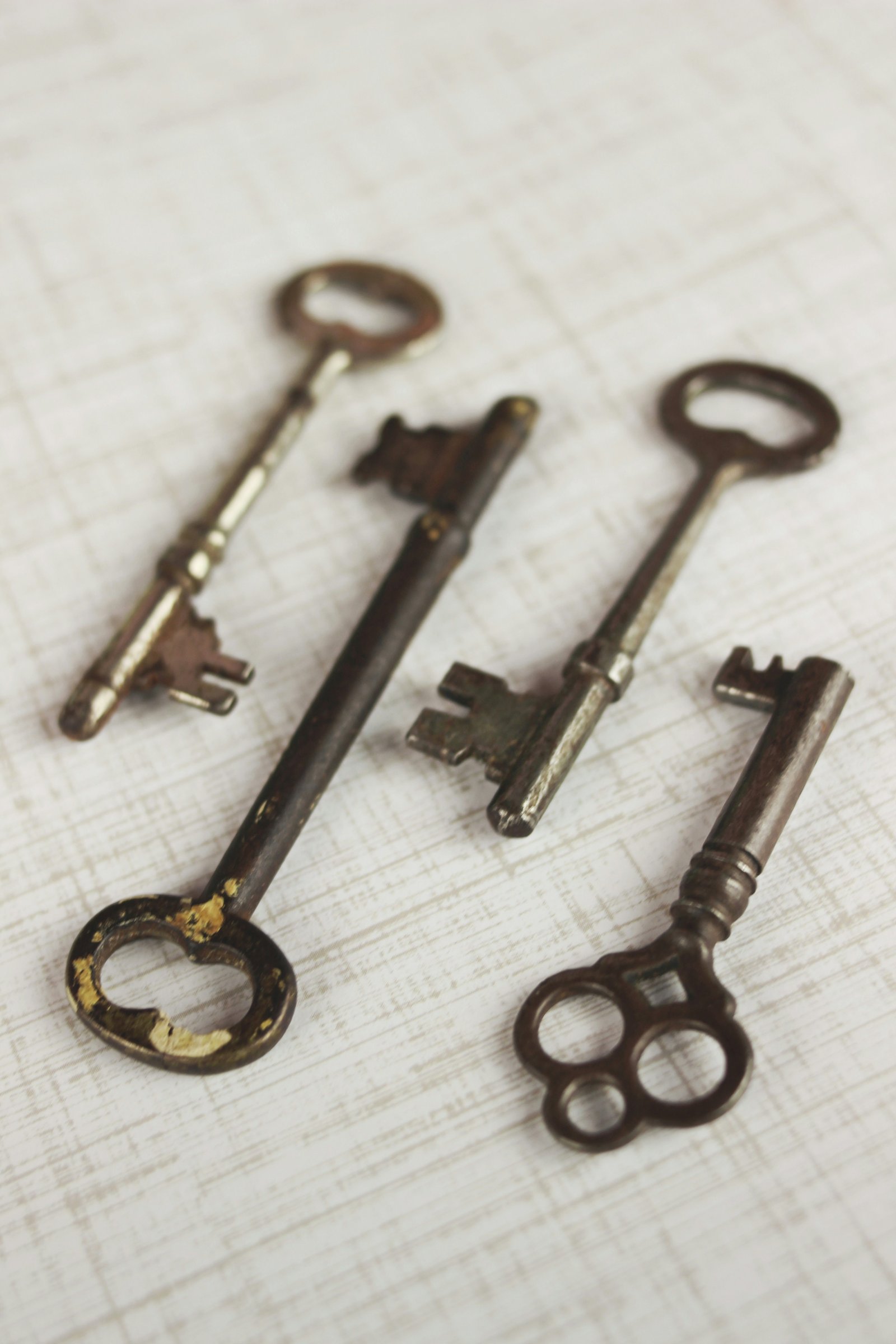 Four old keys lying on a plain cloth