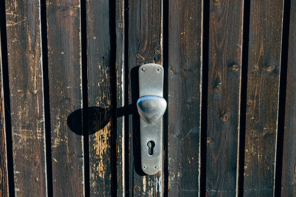 old-keyhole-in-a-dark-wooden-door-with-warm-light-coming-through-it