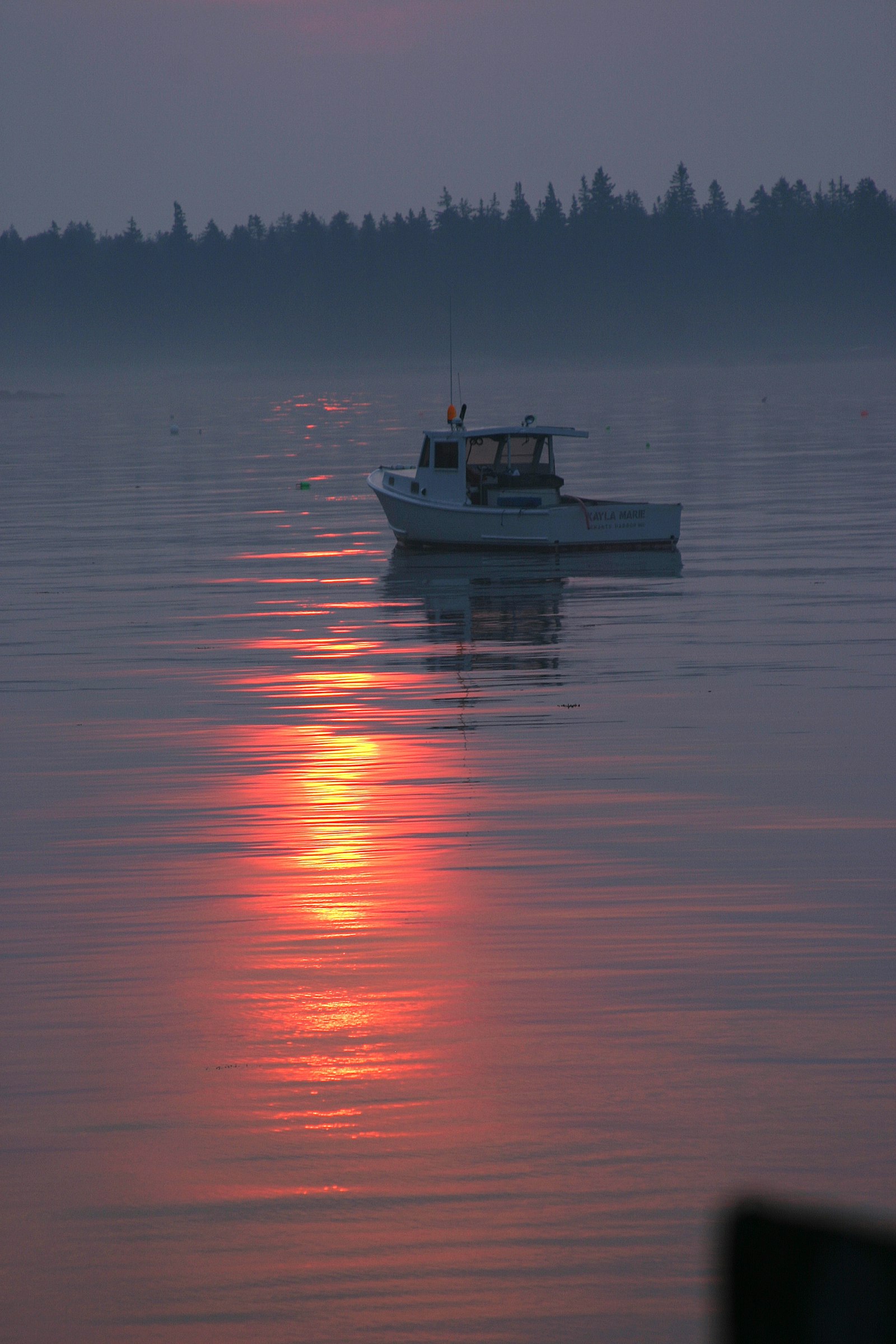 Small boat on calm water at dawn